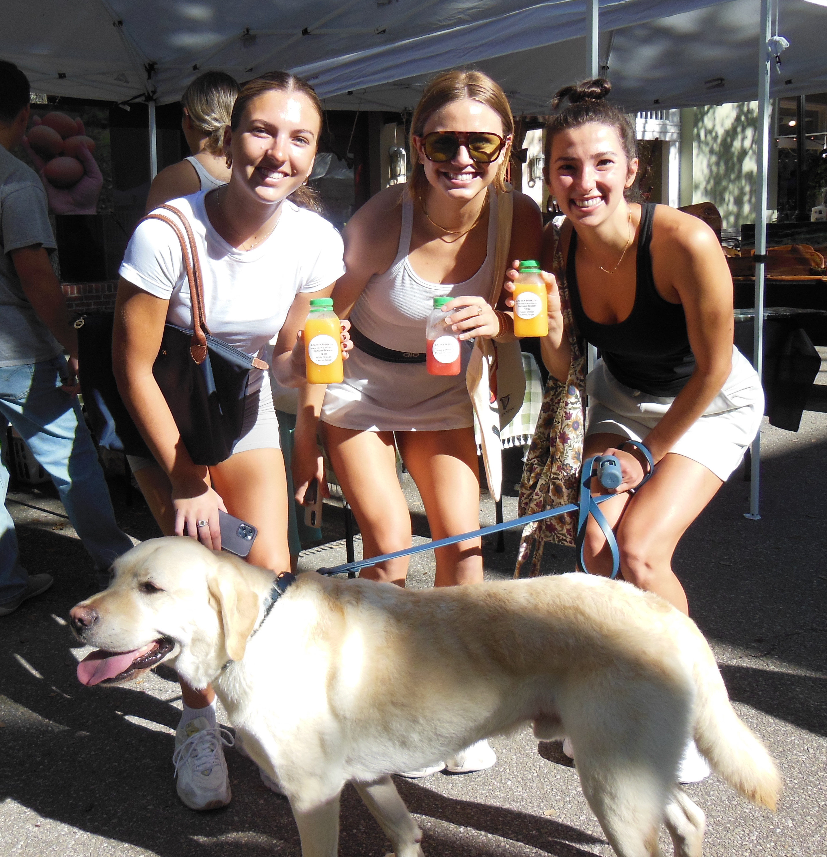 Friends enjoying juices with their dog at the market